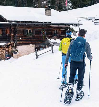 Escursionisti con le ciaspole arrivano ad una baita